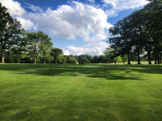 View of golf course with trees lining the fairway